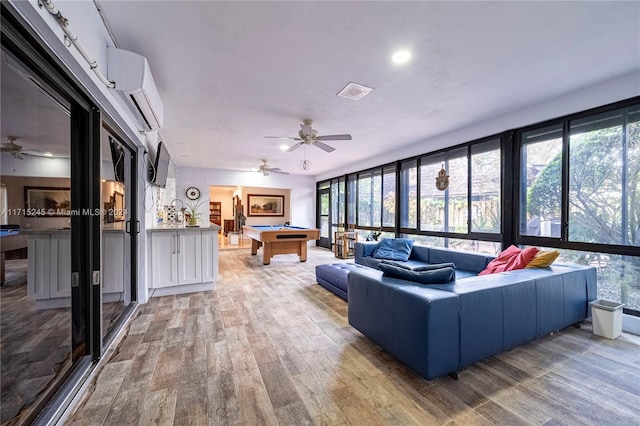 living room featuring hardwood / wood-style flooring, a healthy amount of sunlight, and pool table