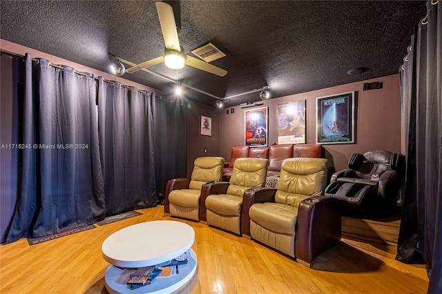 home theater with a textured ceiling and light wood-type flooring