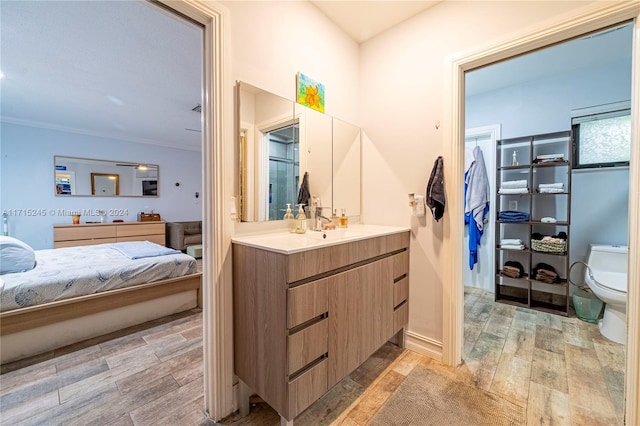 bathroom with vanity, toilet, and crown molding