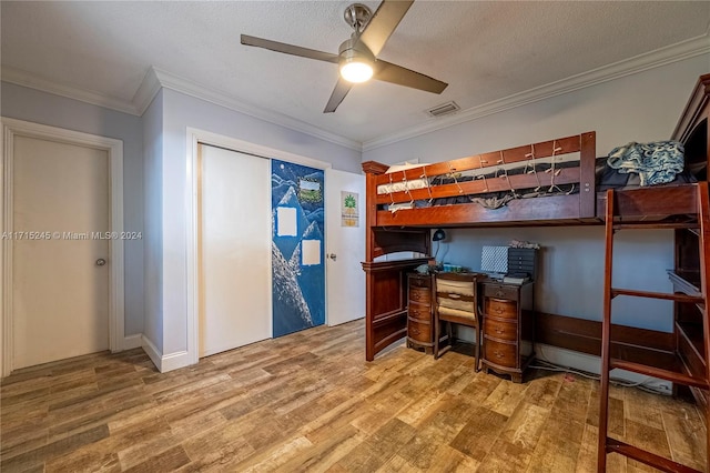 bedroom with hardwood / wood-style floors, ceiling fan, crown molding, and a textured ceiling