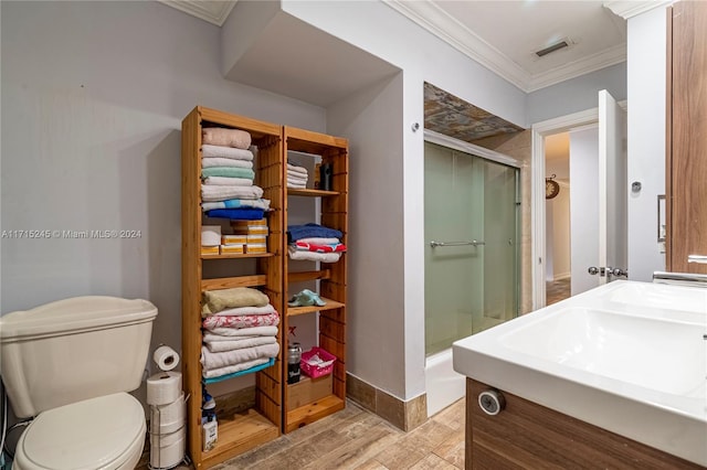 bathroom with vanity, crown molding, hardwood / wood-style flooring, toilet, and an enclosed shower