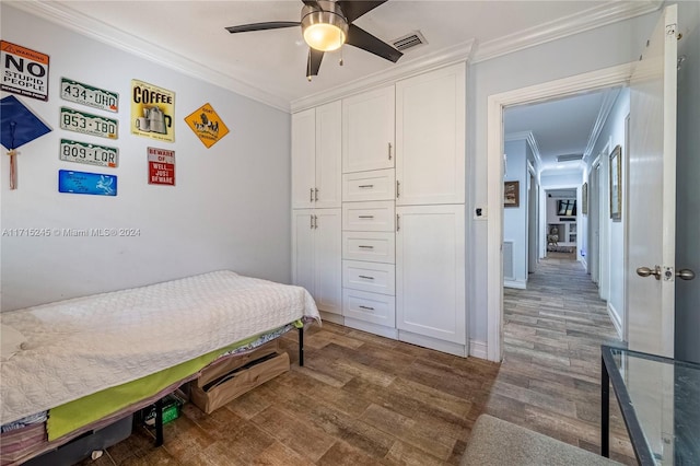 bedroom featuring a closet, dark hardwood / wood-style floors, ceiling fan, and crown molding