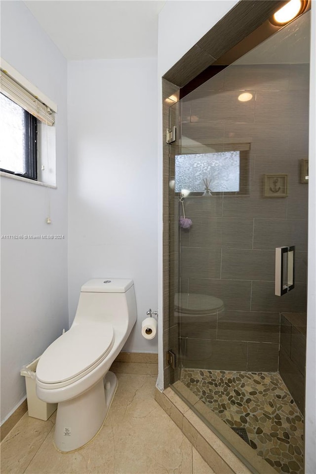 bathroom with tile patterned floors, toilet, and an enclosed shower