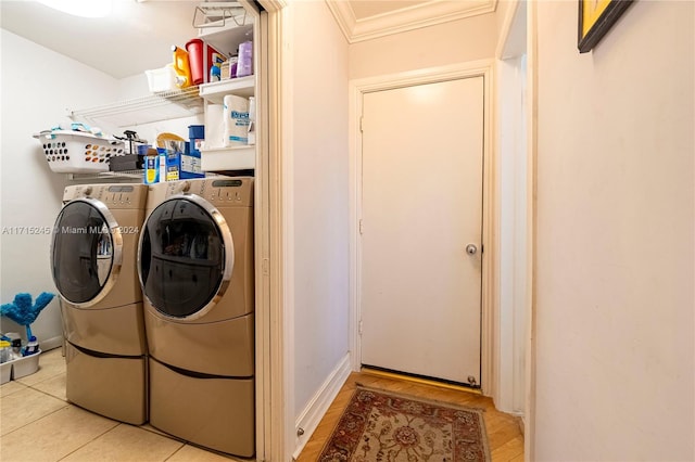 washroom with washer and clothes dryer, ornamental molding, and light tile patterned floors