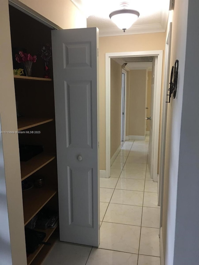 hall featuring ornamental molding and light tile patterned floors