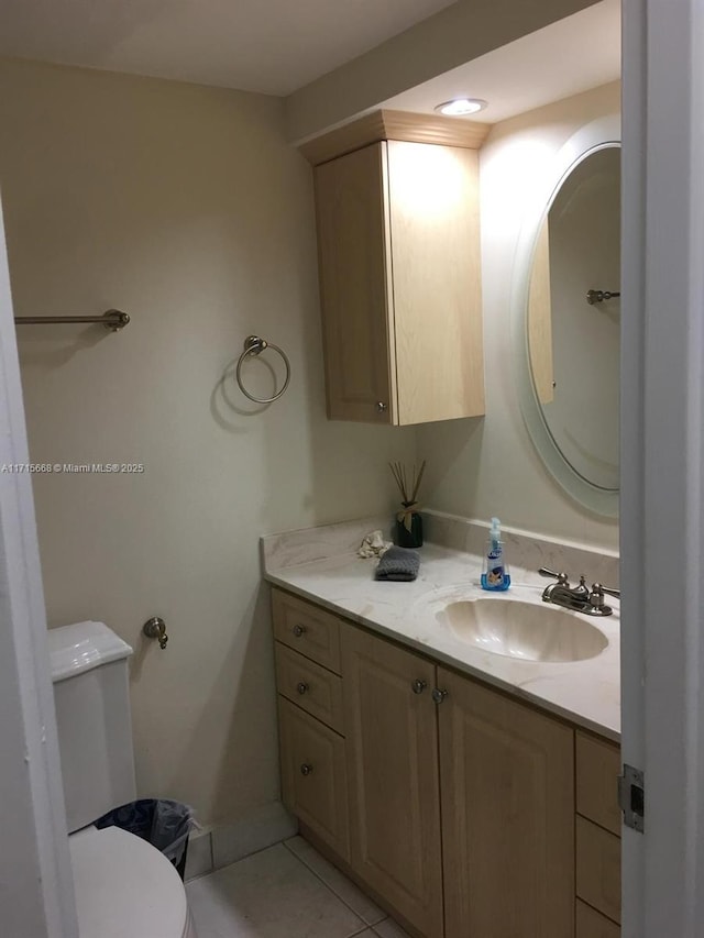 half bathroom with tile patterned flooring, vanity, and toilet