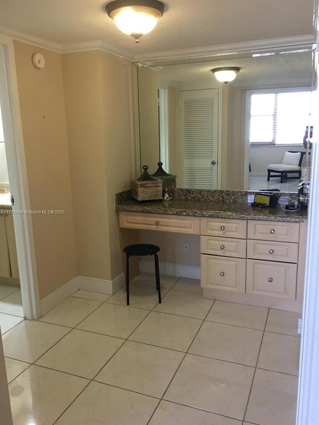 bathroom featuring ornamental molding, tile patterned flooring, vanity, and baseboards