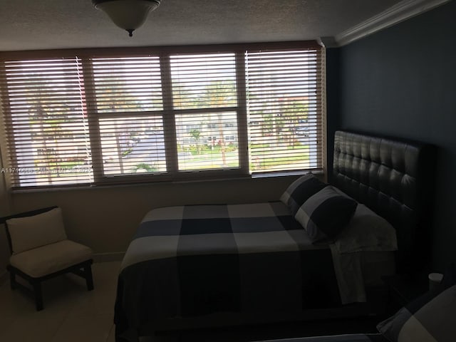 tiled bedroom featuring a textured ceiling and ornamental molding