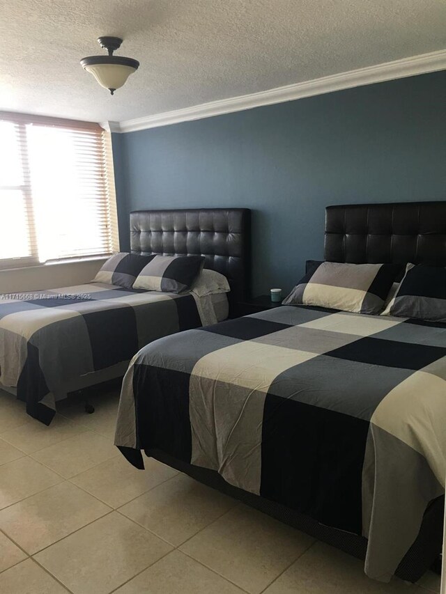 tiled bedroom featuring crown molding and a textured ceiling