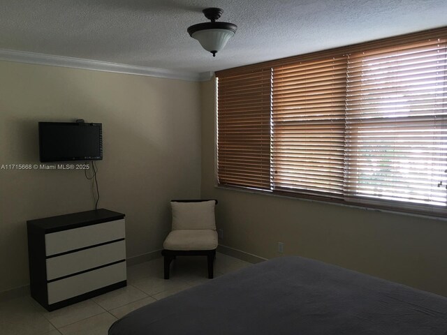 tiled bedroom with a textured ceiling and ornamental molding