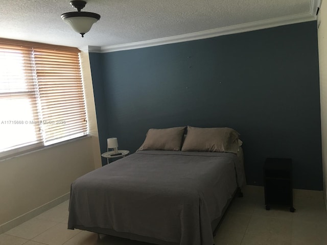 bedroom featuring a textured ceiling, baseboards, crown molding, and light tile patterned flooring