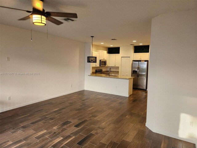 unfurnished living room featuring dark hardwood / wood-style floors, ceiling fan, and sink