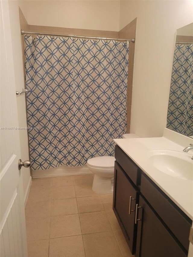 full bathroom featuring tile patterned flooring, vanity, toilet, and shower / bathtub combination with curtain