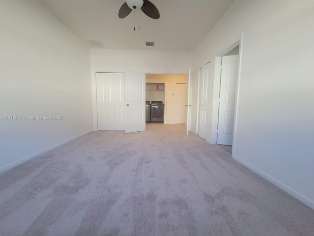 carpeted empty room featuring ceiling fan and washing machine and clothes dryer