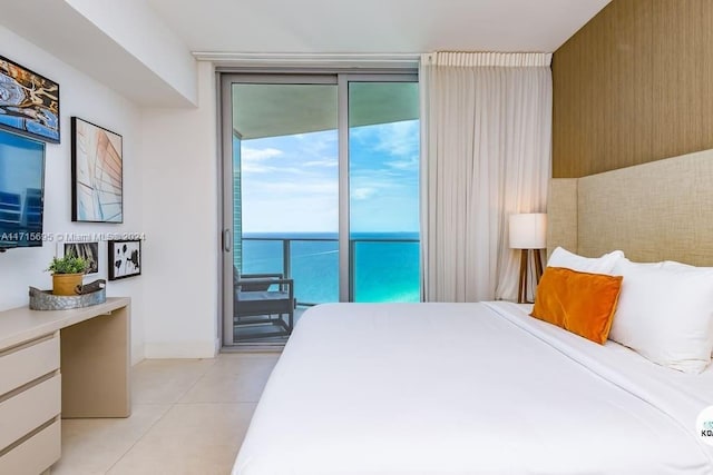 bedroom featuring light tile patterned floors, access to exterior, a wall of windows, and a water view