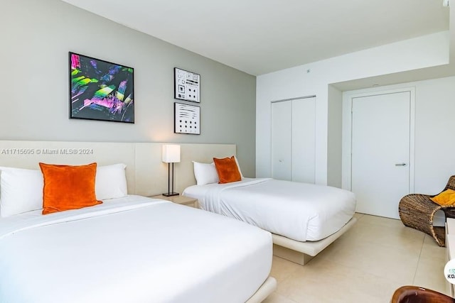 bedroom with a closet and light tile patterned flooring