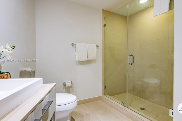 bathroom featuring tile patterned flooring, vanity, a shower with door, and toilet