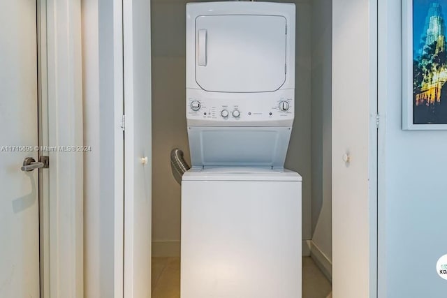 clothes washing area with stacked washing maching and dryer