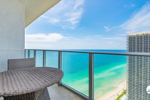 balcony featuring a beach view and a water view