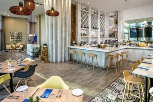 bar with hardwood / wood-style floors and hanging light fixtures