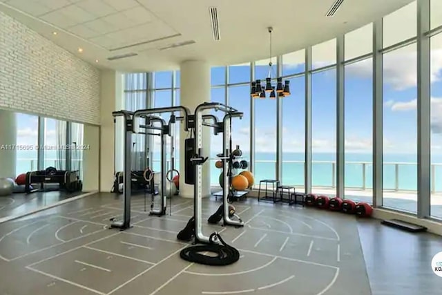 exercise room with a water view and expansive windows