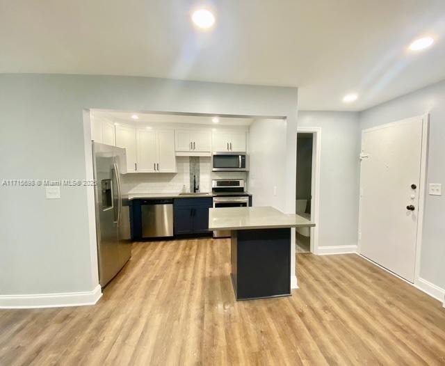 kitchen featuring sink, white cabinetry, tasteful backsplash, light hardwood / wood-style flooring, and stainless steel appliances