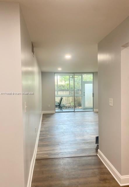 corridor featuring dark hardwood / wood-style flooring and a wall of windows