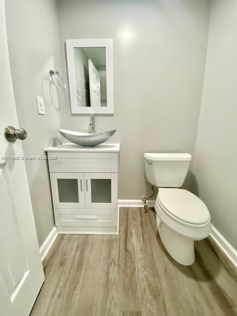 bathroom featuring hardwood / wood-style flooring, vanity, and toilet