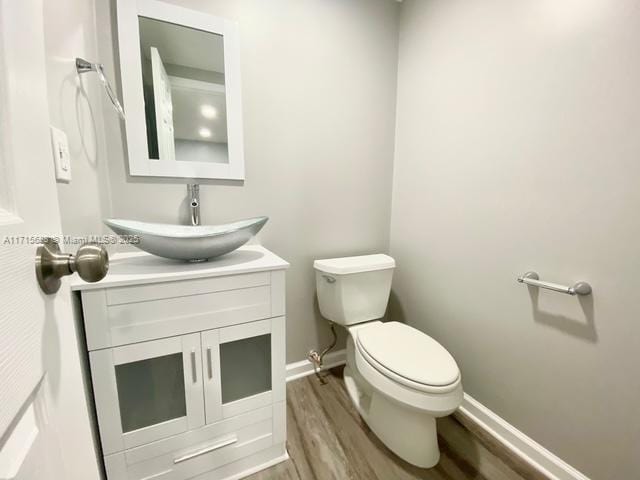 bathroom with vanity, toilet, and wood-type flooring