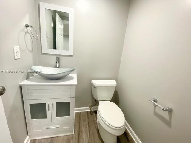 bathroom featuring vanity, hardwood / wood-style floors, and toilet