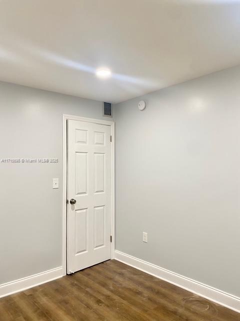 spare room with dark hardwood / wood-style flooring