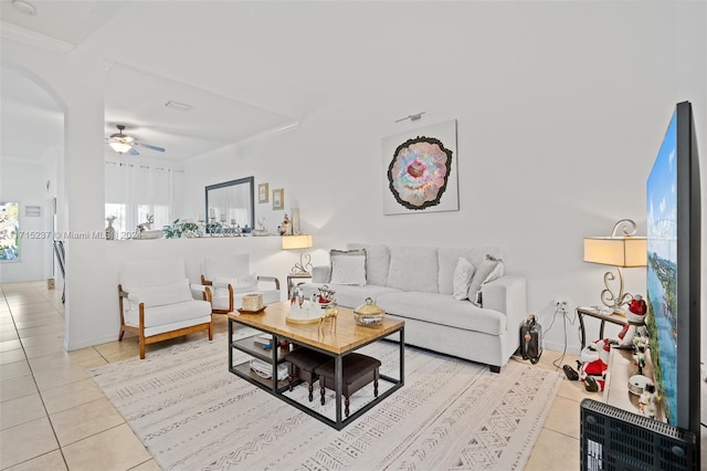 tiled living room featuring ceiling fan and crown molding