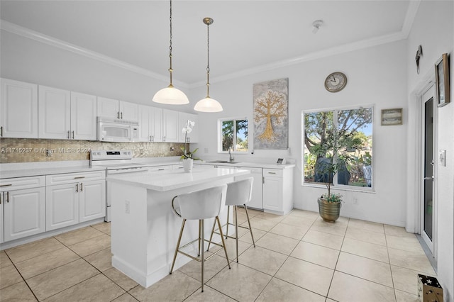 kitchen featuring white cabinets, decorative backsplash, white appliances, and a center island