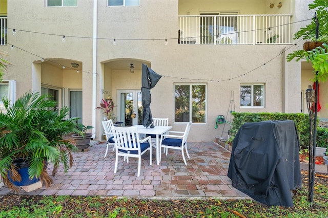 view of patio with a balcony and a grill