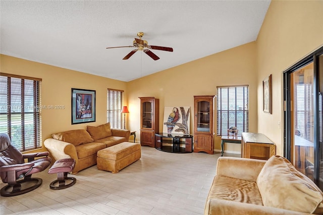 living room featuring a textured ceiling, ceiling fan, light hardwood / wood-style floors, and lofted ceiling