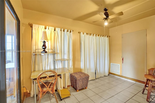 sitting room with ceiling fan and tile patterned flooring