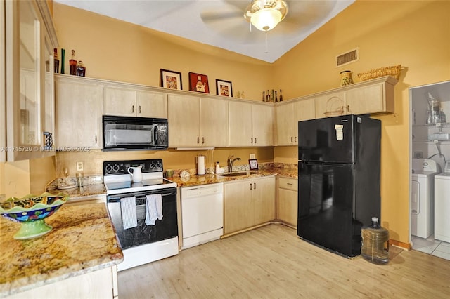 kitchen featuring black appliances, independent washer and dryer, sink, and light brown cabinetry