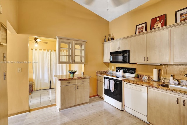 kitchen with light stone countertops, light wood-type flooring, white appliances, sink, and light brown cabinets