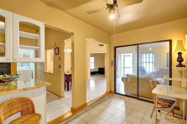 entryway featuring ceiling fan, light tile patterned flooring, and washer / dryer