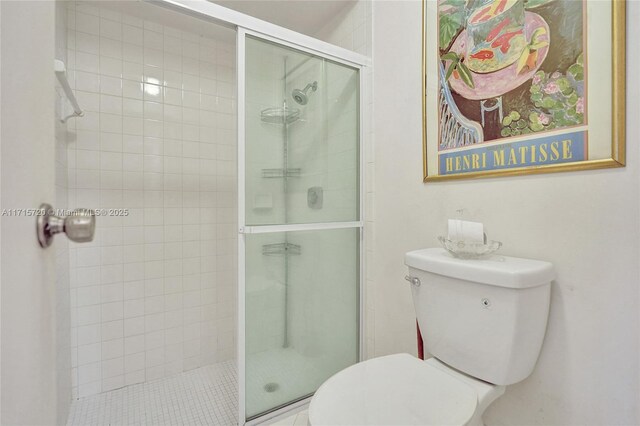 bathroom featuring toilet and an enclosed shower