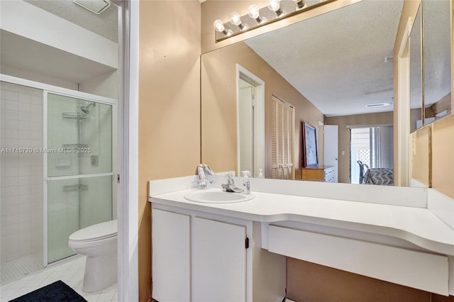 bathroom featuring a textured ceiling, vanity, a shower with door, tile patterned flooring, and toilet