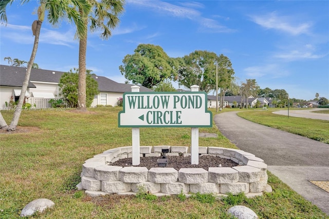 community / neighborhood sign featuring a lawn