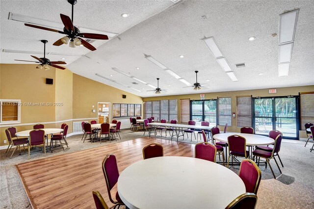 dining space with a textured ceiling, ceiling fan, and lofted ceiling