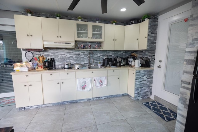 kitchen with light tile patterned floors, backsplash, ceiling fan, and sink