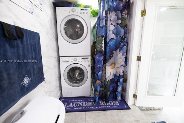 clothes washing area featuring stacked washing maching and dryer