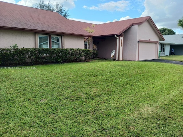 ranch-style home with a garage and a front lawn