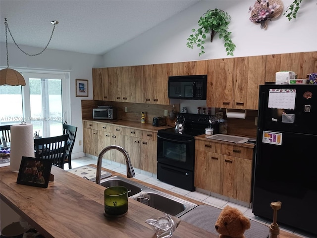 kitchen with lofted ceiling, black appliances, sink, decorative backsplash, and light tile patterned floors