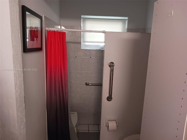 bathroom featuring curtained shower and toilet