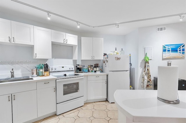 kitchen with white appliances, visible vents, a sink, light countertops, and white cabinets