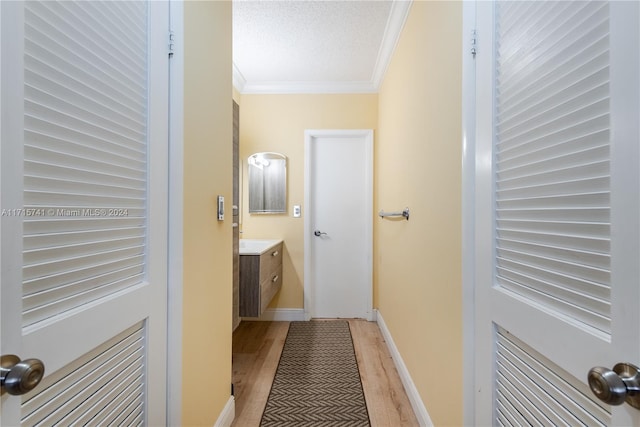 bathroom featuring crown molding, hardwood / wood-style floors, vanity, and a textured ceiling